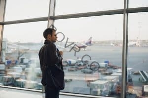 Man waiting for flight home looking at planes